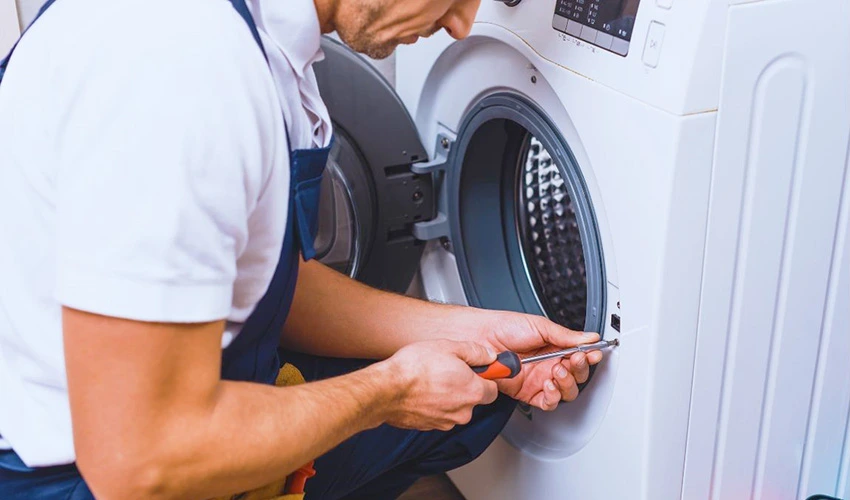 Technician inspecting a front-loading washing machine