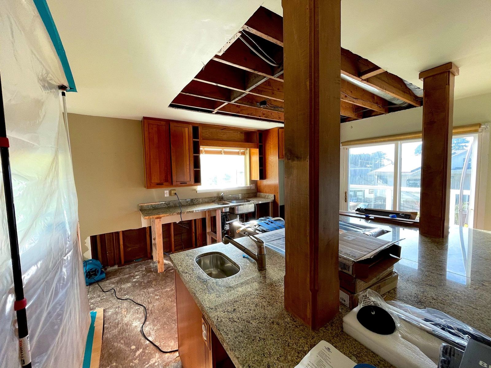 Kitchen with removed wall and ceiling drywall after an ice-maker leak