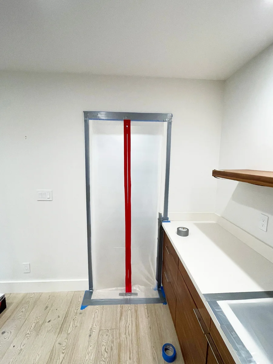 Zippered containment doorway beside a bathroom vanity — San Francisco, CA