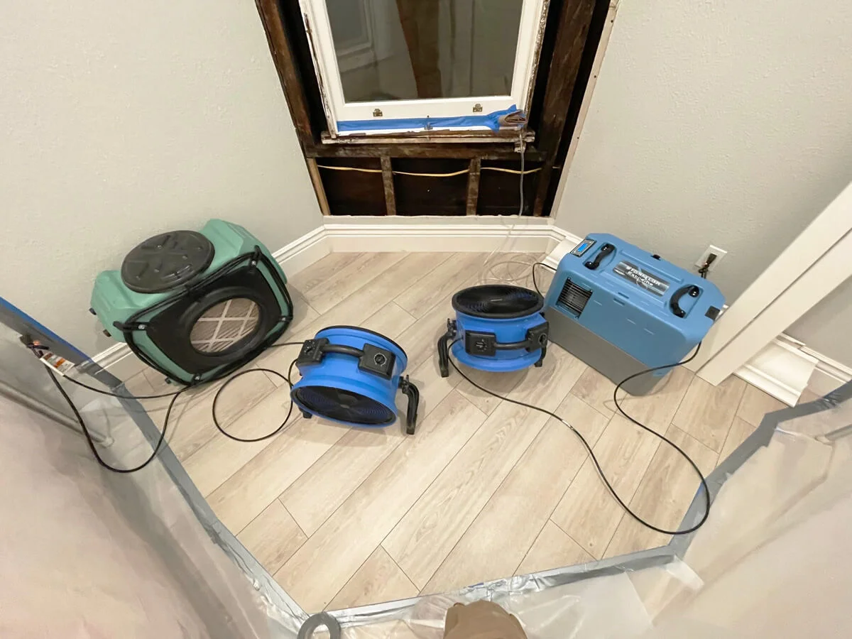 Air movers and a dehumidifier drying the wall below a window — San Francisco, CA