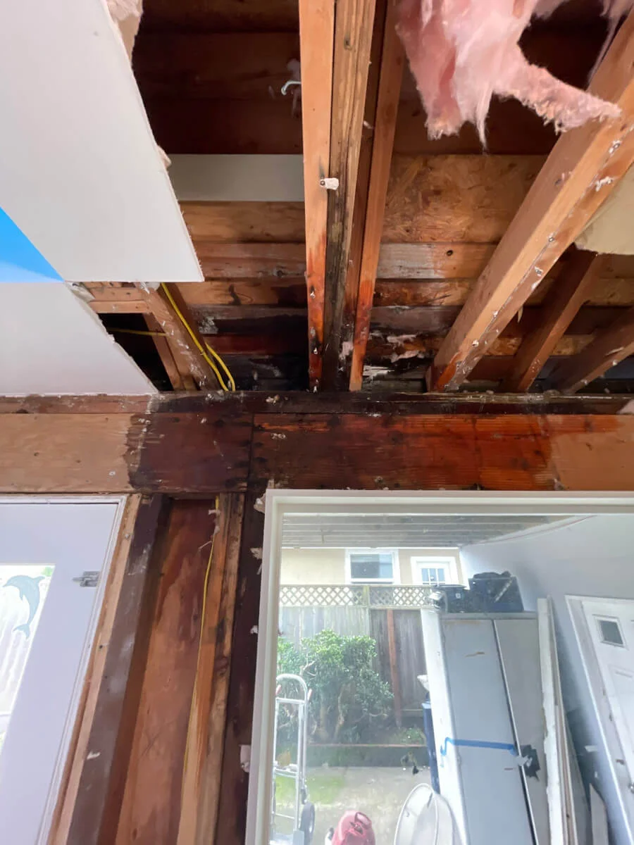 Opened ceiling and wall framing above a glazed door — Pacifica, CA