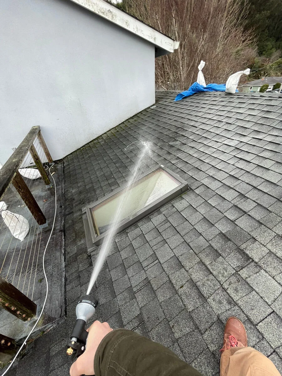 Water hose testing a shingle roof beside a skylight — Pacifica, CA