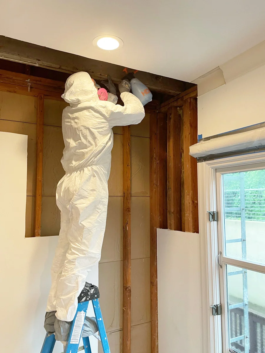 Technician treating exposed wood framing above a doorway — San Francisco, CA