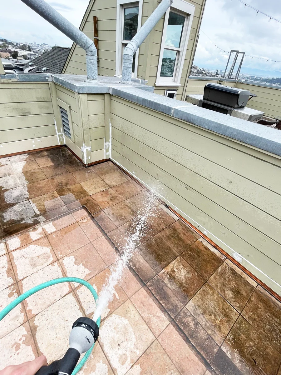 Water hose on a tiled balcony beside a window during testing — San Francisco, CA
