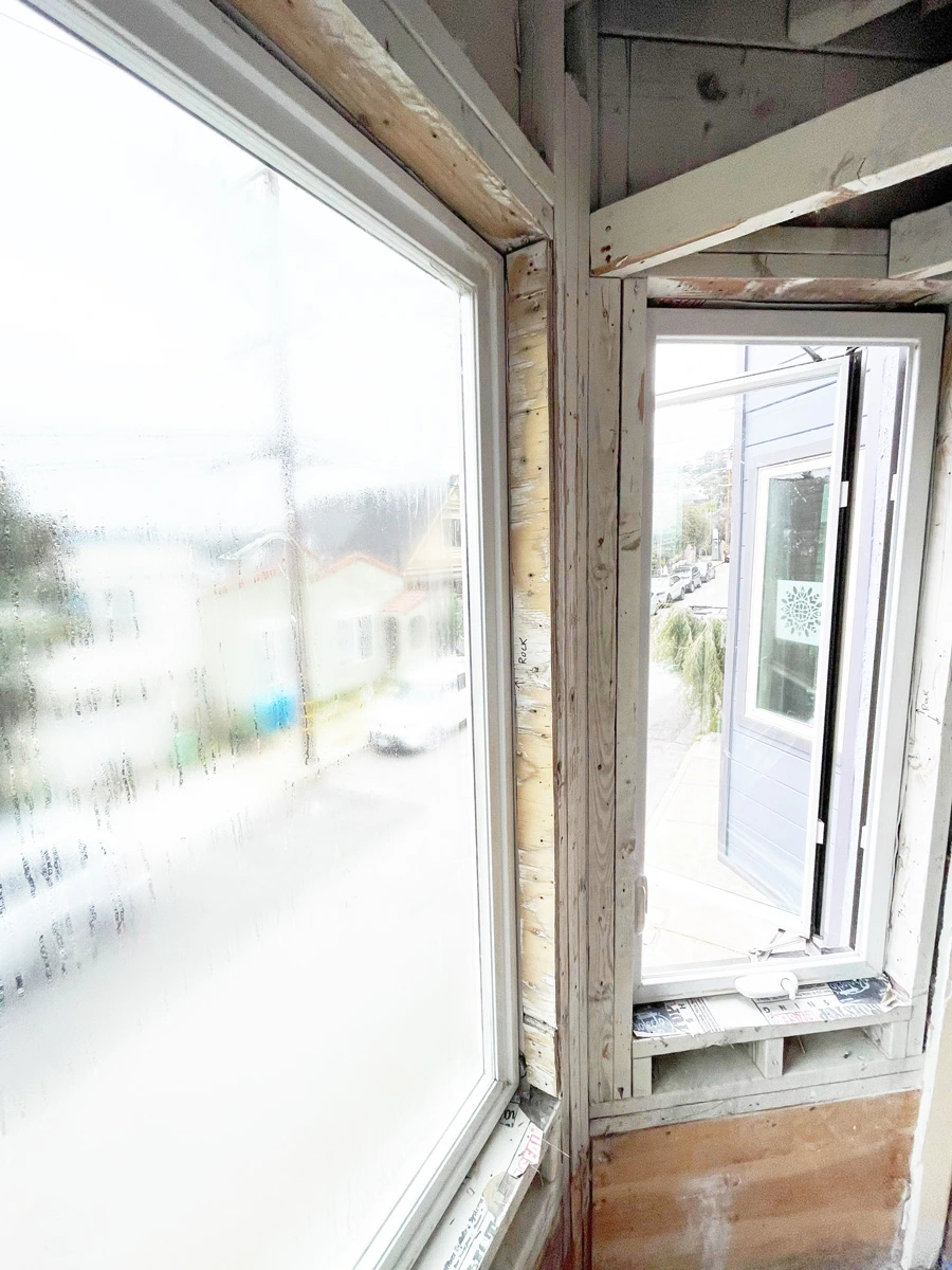 Exposed wall framing beside a bay window after drywall removal — San Francisco, CA