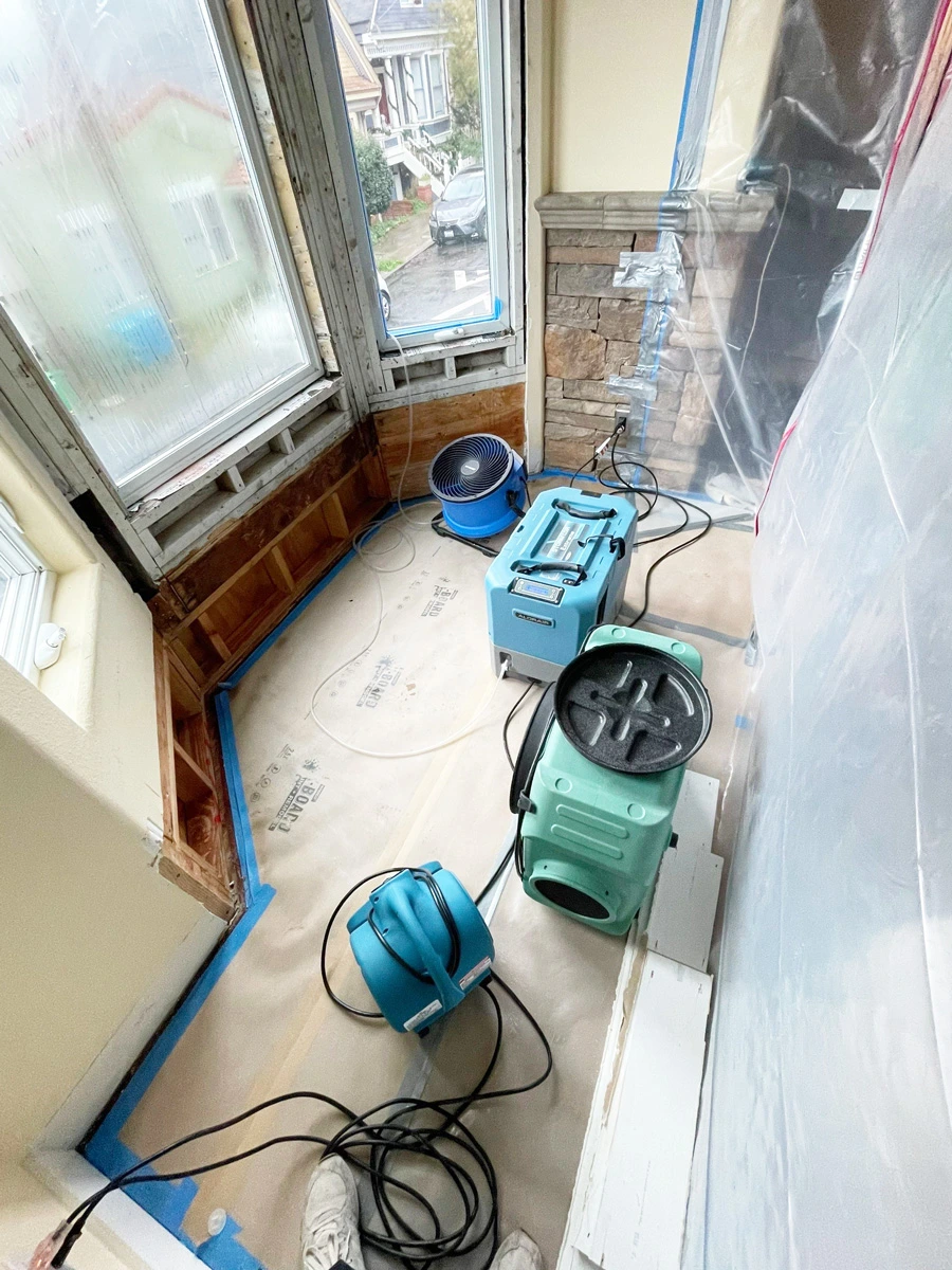 Air movers drying the exposed walls below a bay window — San Francisco, CA