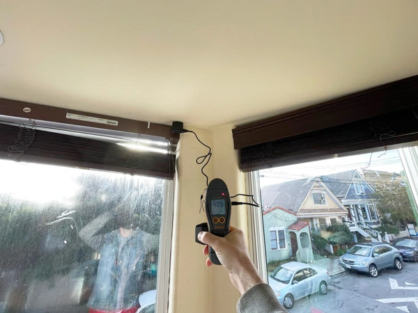 Moisture meter checking a wall beside a bay window — San Francisco, CA