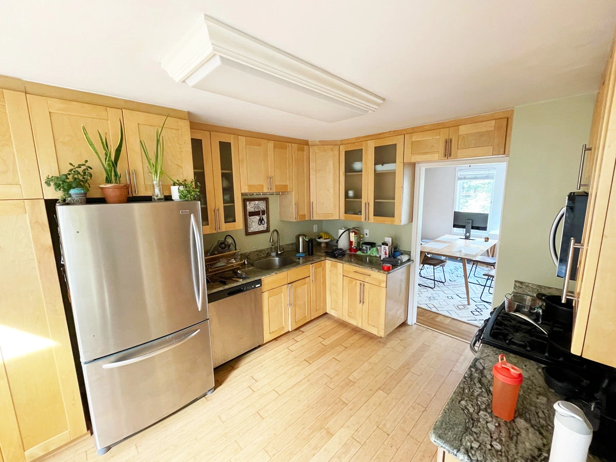 Kitchen with wood cabinets and a refrigerator before repairs — San Francisco, CA