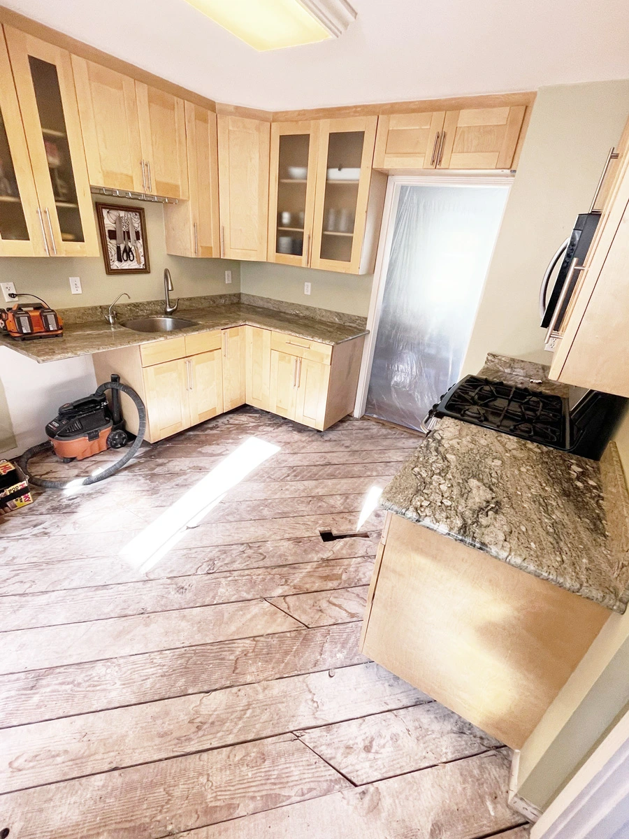 Exposed plank subfloor beside kitchen cabinets before floor replacement — San Francisco, CA
