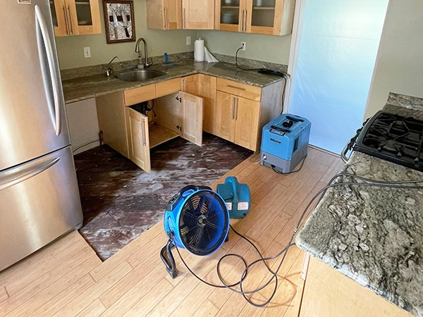 Air movers drying a kitchen with lower cabinets removed — San Francisco, CA